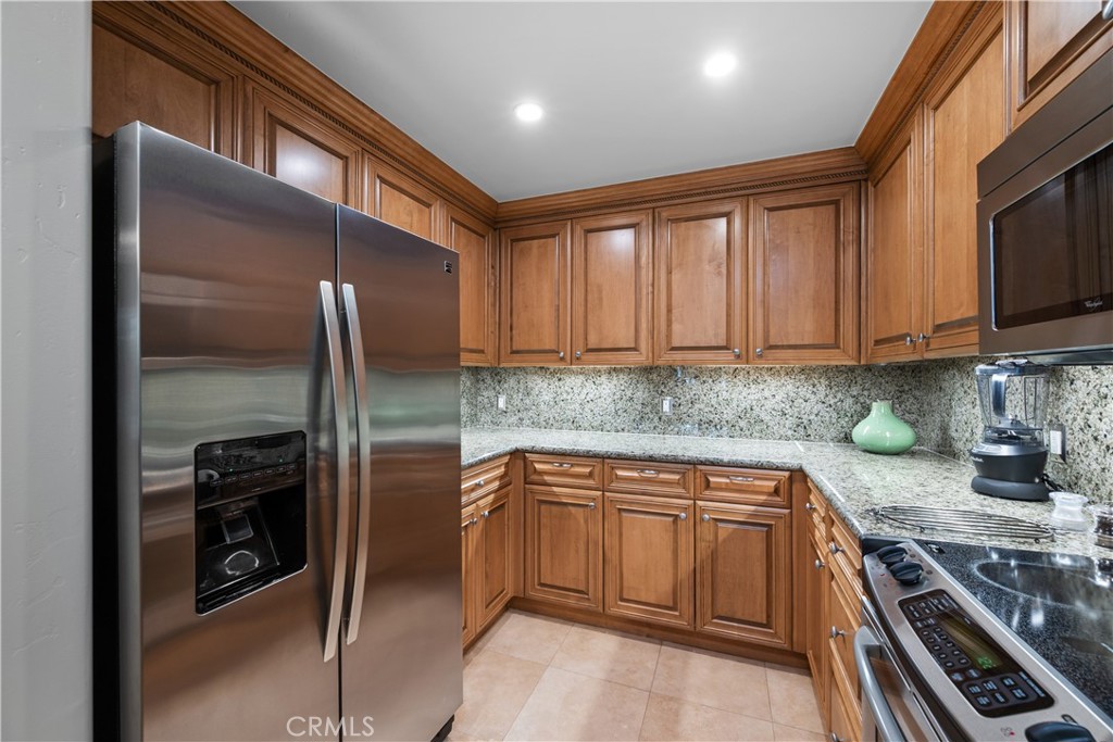 2727 Shell Beach Road, Unit 219 Pismo Beach, CA 93449 - Photo 12 of 35 a kitchen with stainless steel appliances granite countertop a refrigerator and a stove top oven