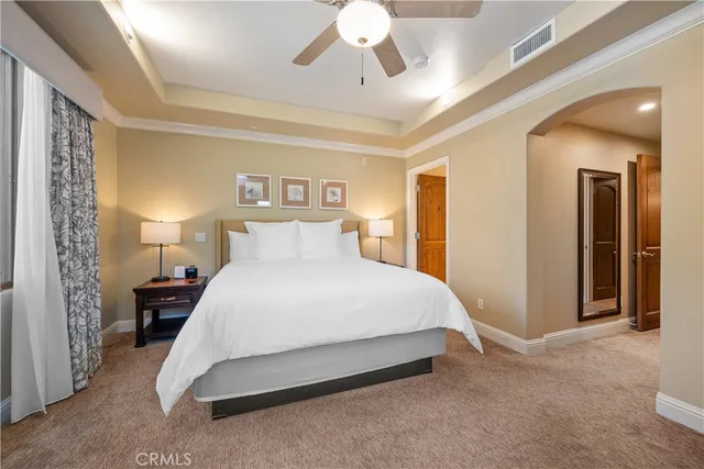 a spacious bedroom with a bed and a chandelier