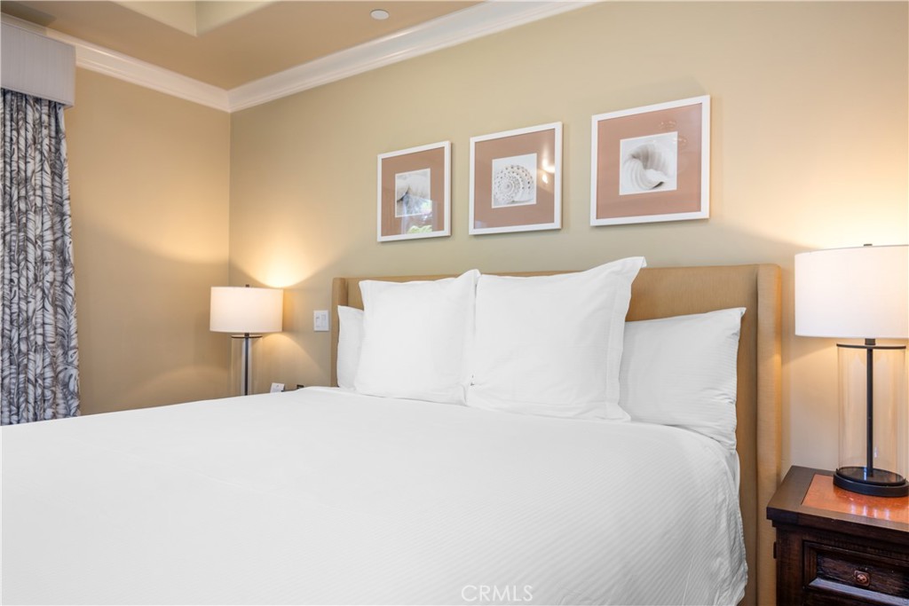 2727 Shell Beach Road, Unit 219 Pismo Beach, CA 93449 - Photo 16 of 35 a large bed sitting in a bedroom next to a lamp