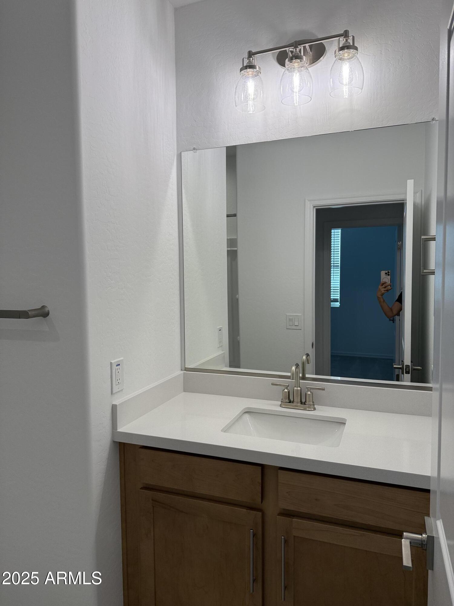 9960 West Mitchell Avenue Avondale, AZ 85392 - Photo 15 of 25 a bathroom with a sink and a mirror