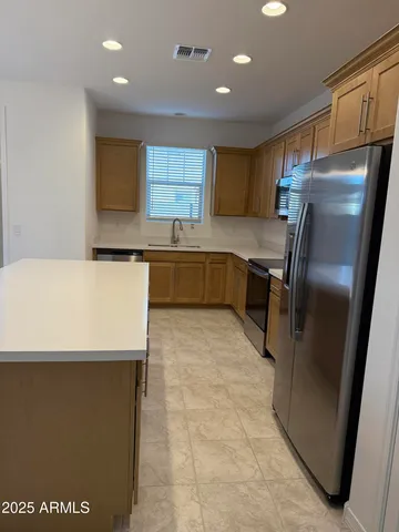 a kitchen with stainless steel appliances a refrigerator sink and cabinets