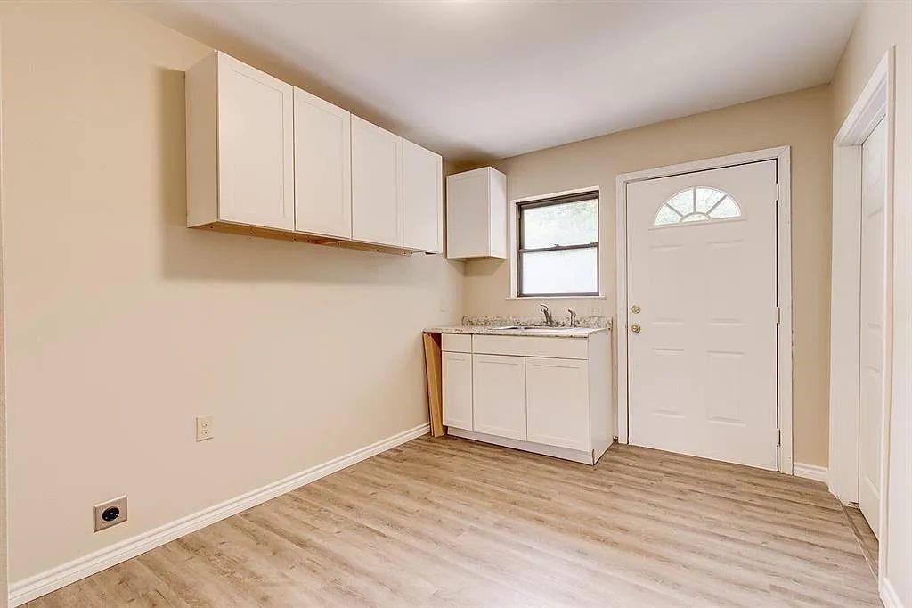 1316 Royster Road Fort Worth, TX 76134 - Photo 17 of 19 a view of a kitchen with wooden floor and electronic appliances