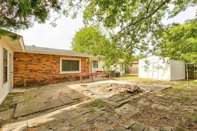 a view of a yard with a house and a large tree