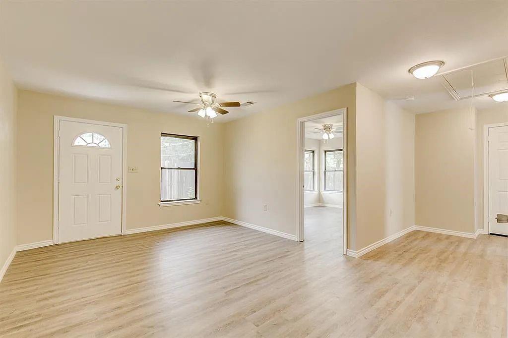 1316 Royster Road Fort Worth, TX 76134 - Photo 2 of 19 an empty room with wooden floor and windows