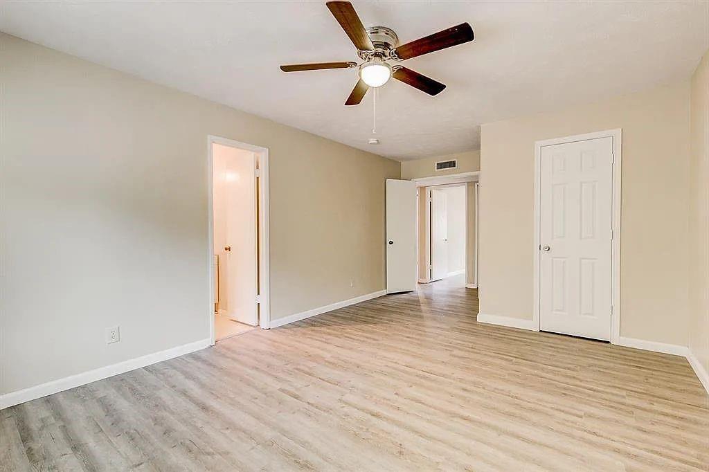 1316 Royster Road Fort Worth, TX 76134 - Photo 9 of 19 an empty room with wooden floor and ceiling fan