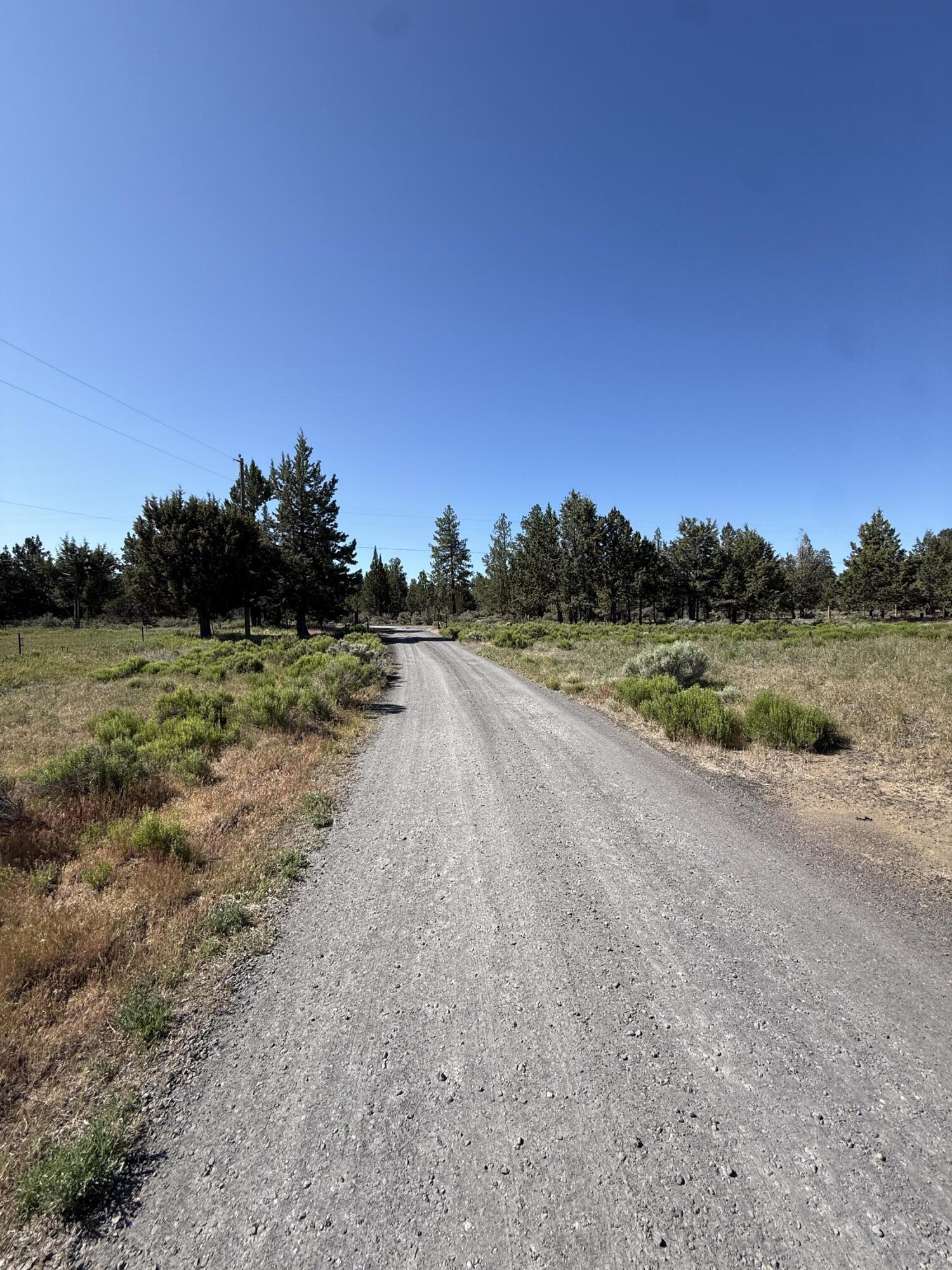 21710 McGilvray Road Bend, OR 97702 - Photo 6 of 7 a view of a dirt road with a building in the background