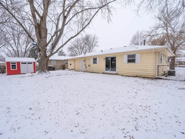a view of a house with a yard covered in snow