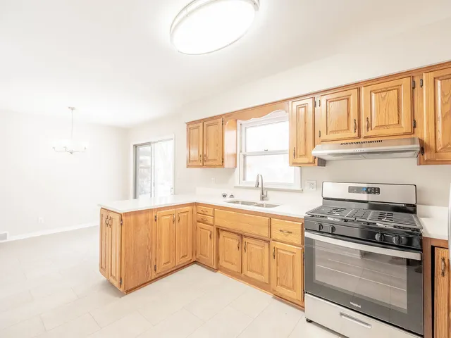 a kitchen with granite countertop a stove sink and cabinets