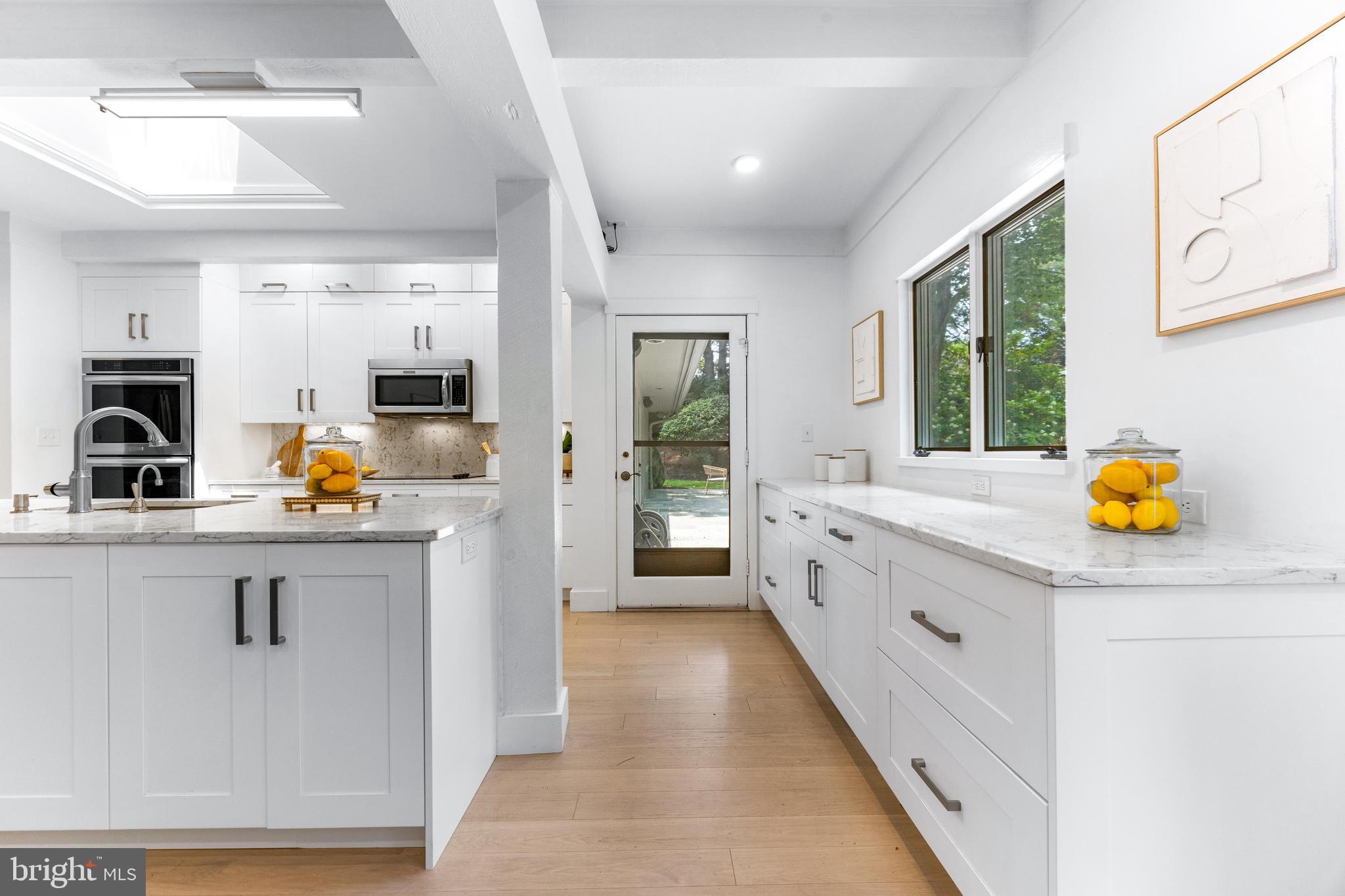 5 Tall Tree Court Baltimore, MD 21208 - Photo 29 of 78 a large white kitchen with stainless steel appliances granite countertop a lot of counter space and a sink