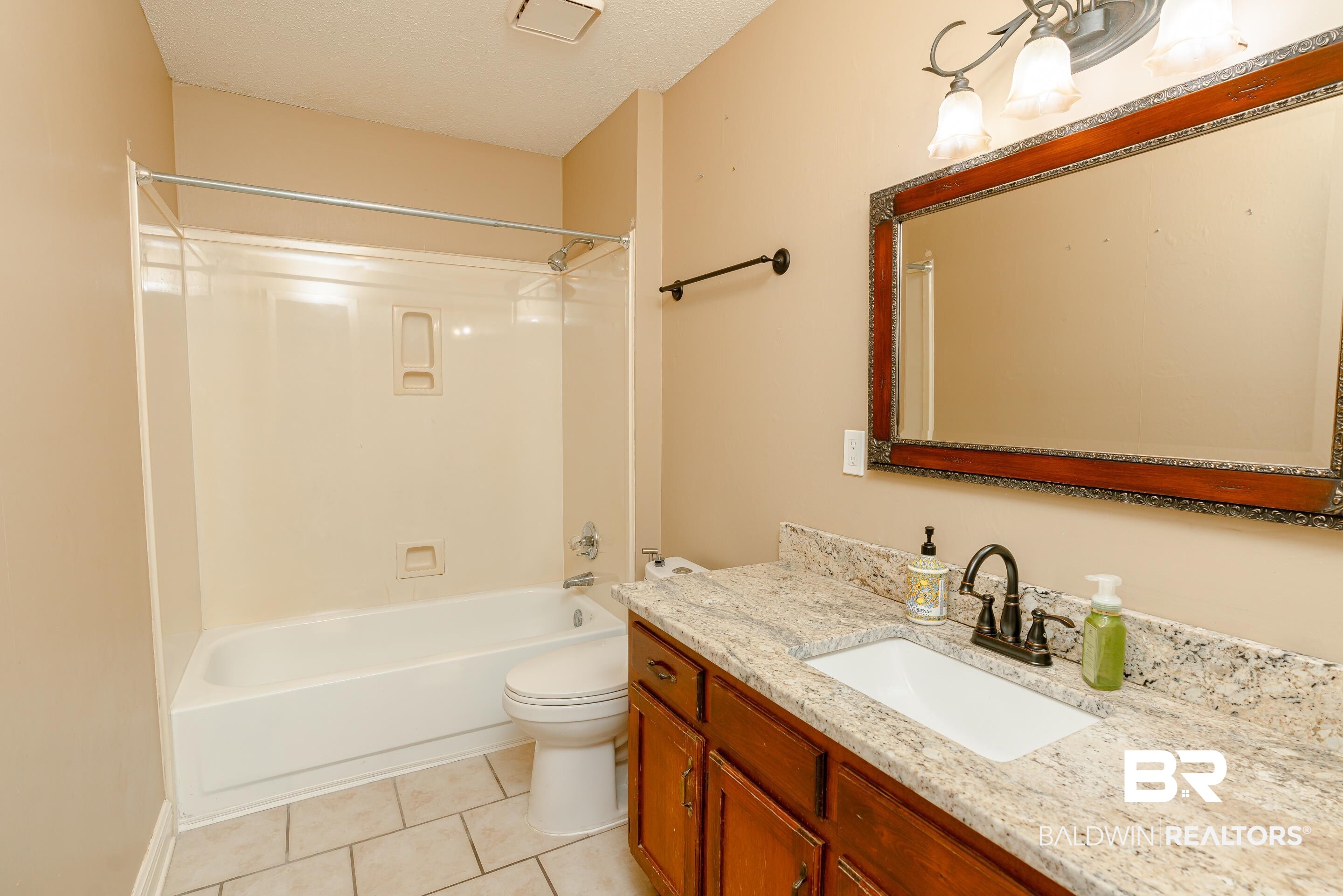 23 Old Mill Court Mobile, AL 36608 - Photo 26 of 37 Full bathroom with vanity, tile patterned flooring, shower combination, and toilet
