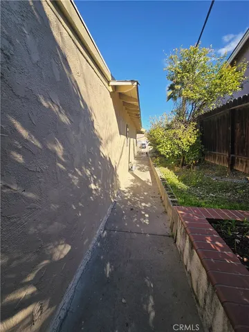 a view of a yard with plants and a bench