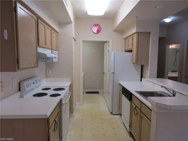 a kitchen that has a sink a stove and a refrigerator