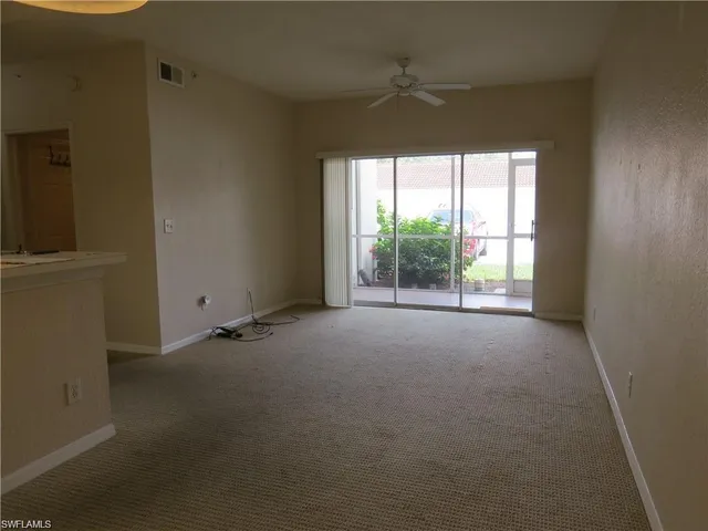 a view of a livingroom with an empty space and a window