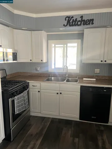 a kitchen with granite countertop a stove a sink and a microwave