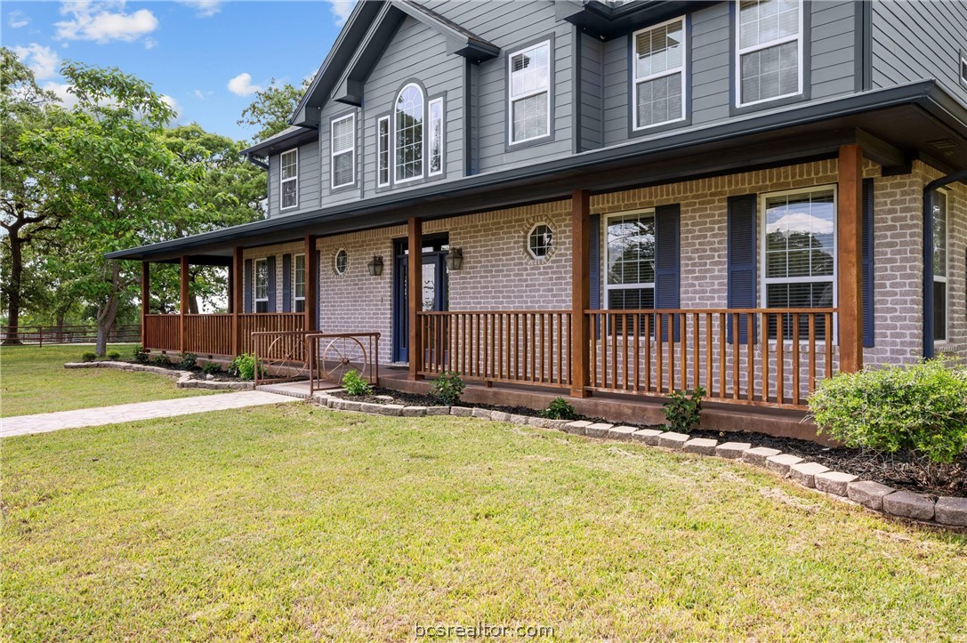 6400 Koppe Bridge Road College Station, TX 77845 - Photo 15 of 47 View of front of house with a covered porch, brick siding, and a front yard view.