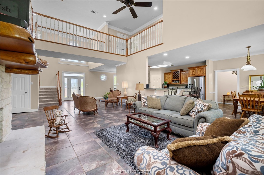 6400 Koppe Bridge Road College Station, TX 77845 - Photo 16 of 47 Living area featuring crown molding, ceiling fan, a high ceiling, and recessed lighting.