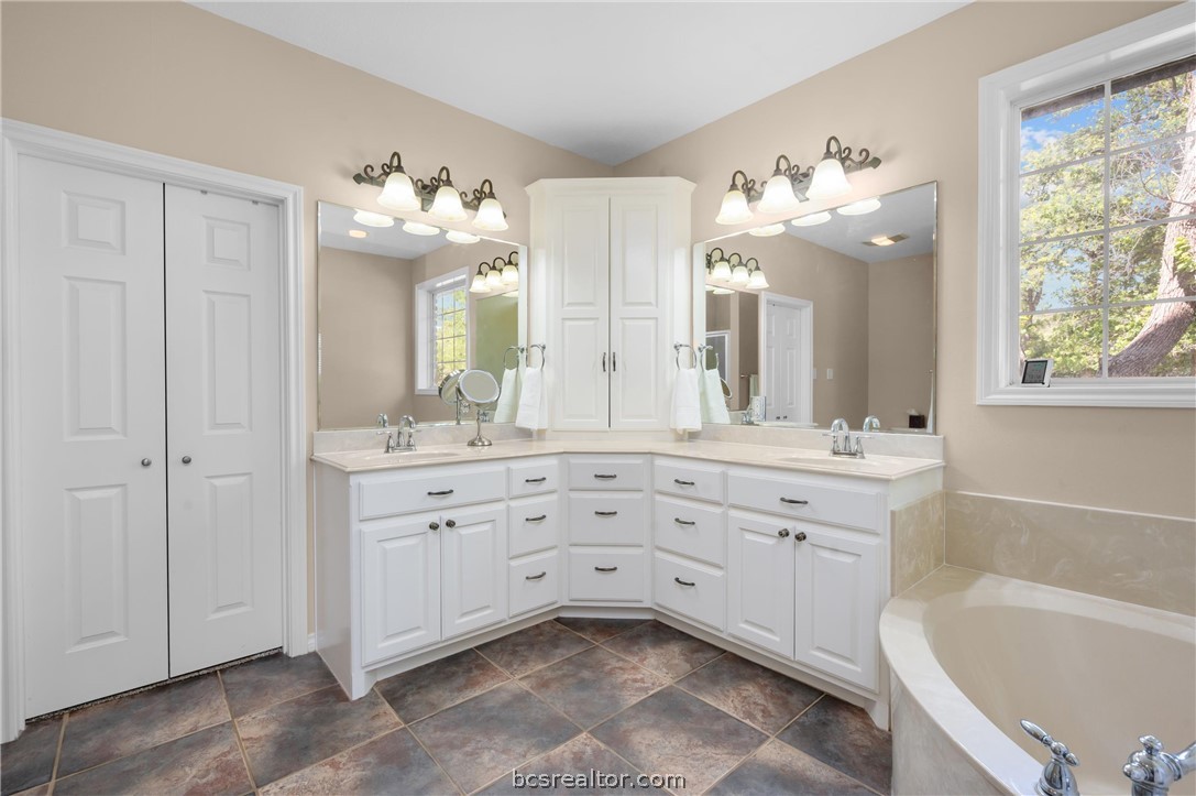 6400 Koppe Bridge Road College Station, TX 77845 - Photo 26 of 47 Primary bathroom featuring double vanity, a bath, and a closet.