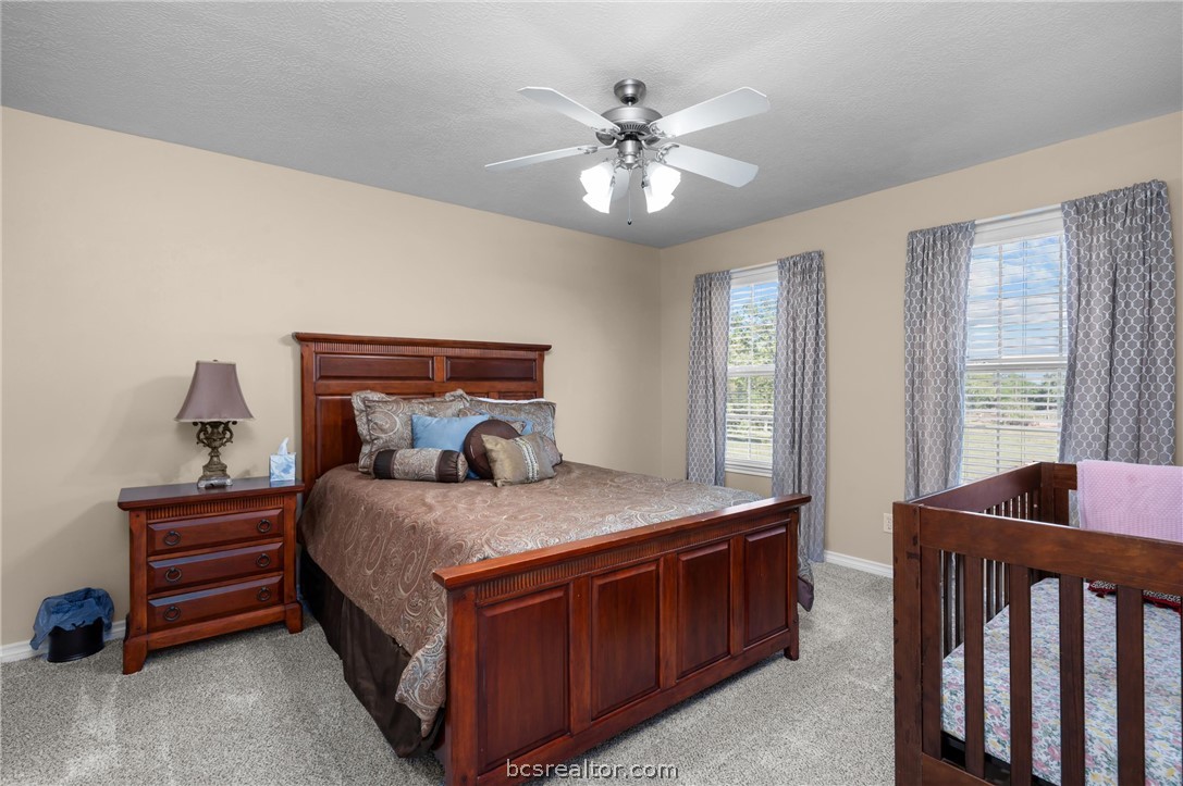 6400 Koppe Bridge Road College Station, TX 77845 - Photo 30 of 47 Upstairs bedroom with ceiling fan and light colored carpet.