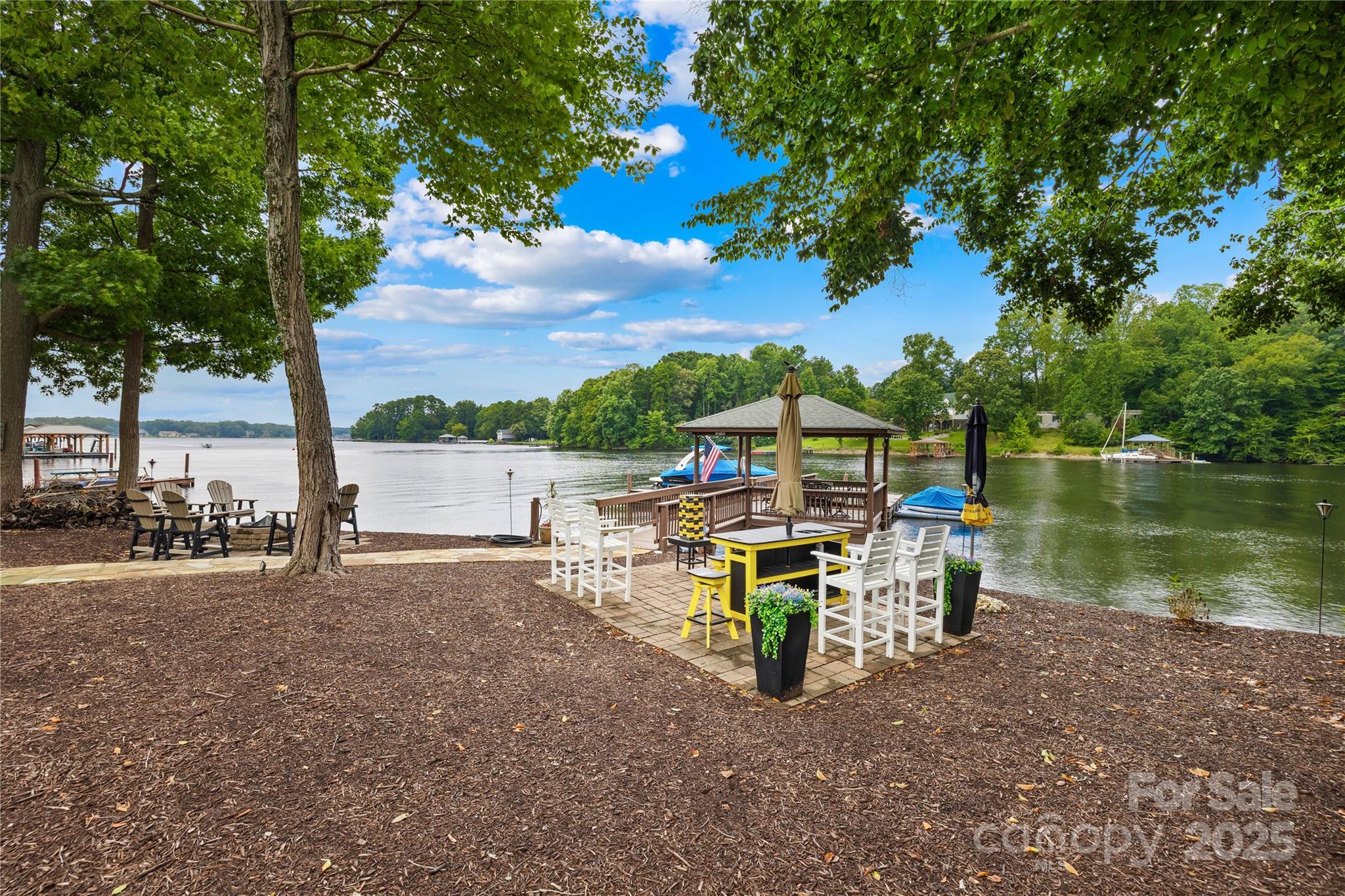 3601 Andover Place Terrell, NC 28682 - Photo 8 of 48 a view of a lake with table and chairs and potted plants and big trees