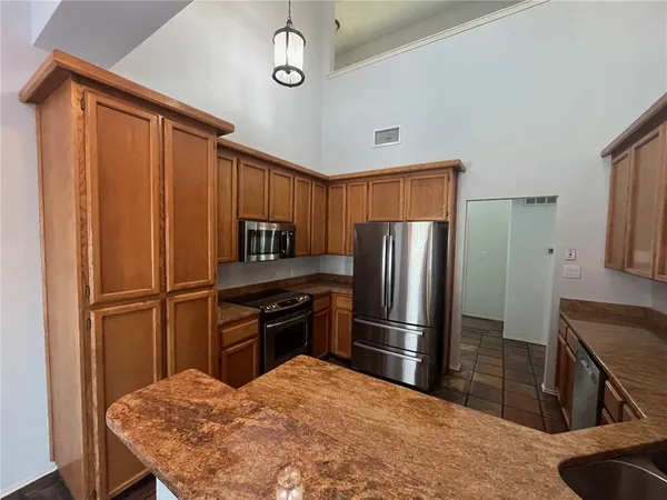 a kitchen with a refrigerator sink and cabinets