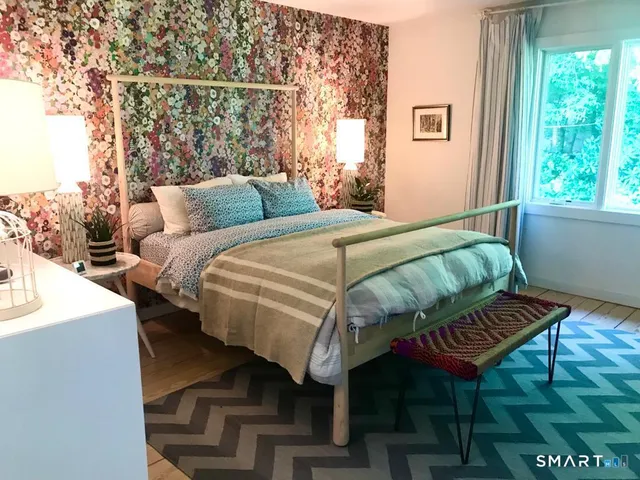 a bed sitting in a bedroom next to a window