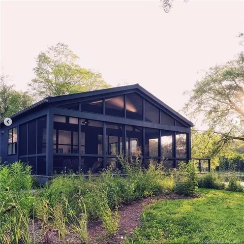 a view of a house with brick walls and a yard with plants