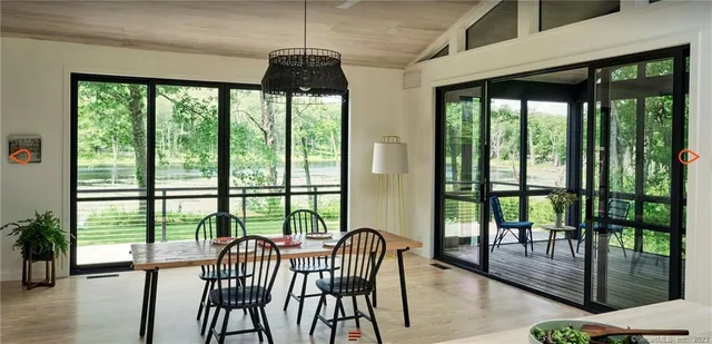 a view of a dining room with furniture large windows and wooden floor