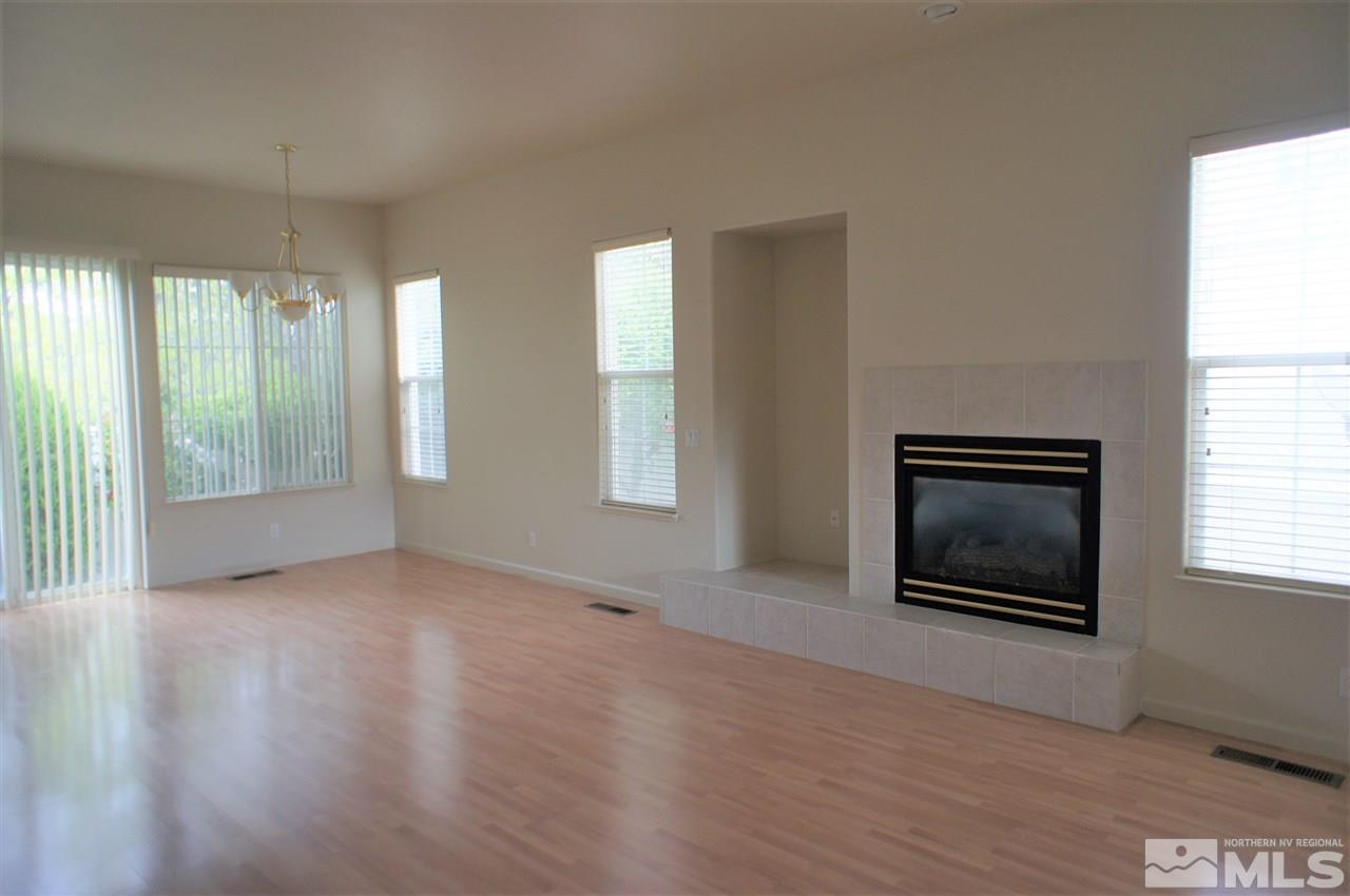 1075 Waverly Drive Reno, NV 89519 - Photo 3 of 17 an empty room with wooden floor fireplace and windows