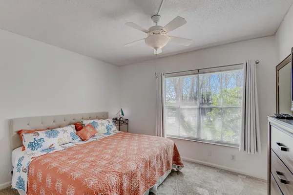 a bedroom with a large bed and a flat tv screen on dresser