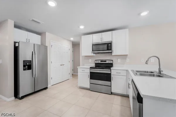 a kitchen with stainless steel appliances a refrigerator sink and stove