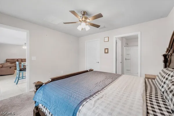 a bedroom with a large bed and a ceiling fan