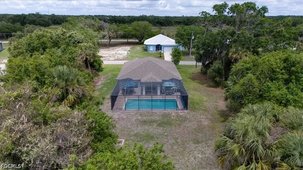 a aerial view of a house with a yard and large tree