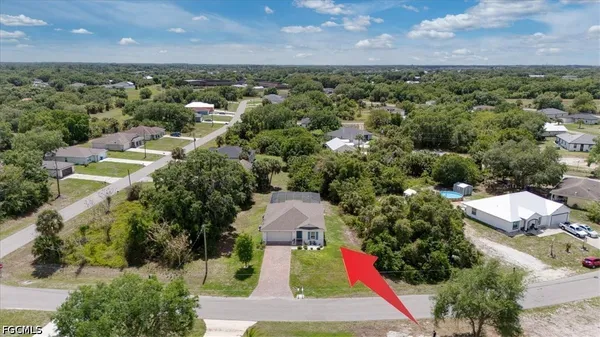 an aerial view of residential houses with outdoor space and trees