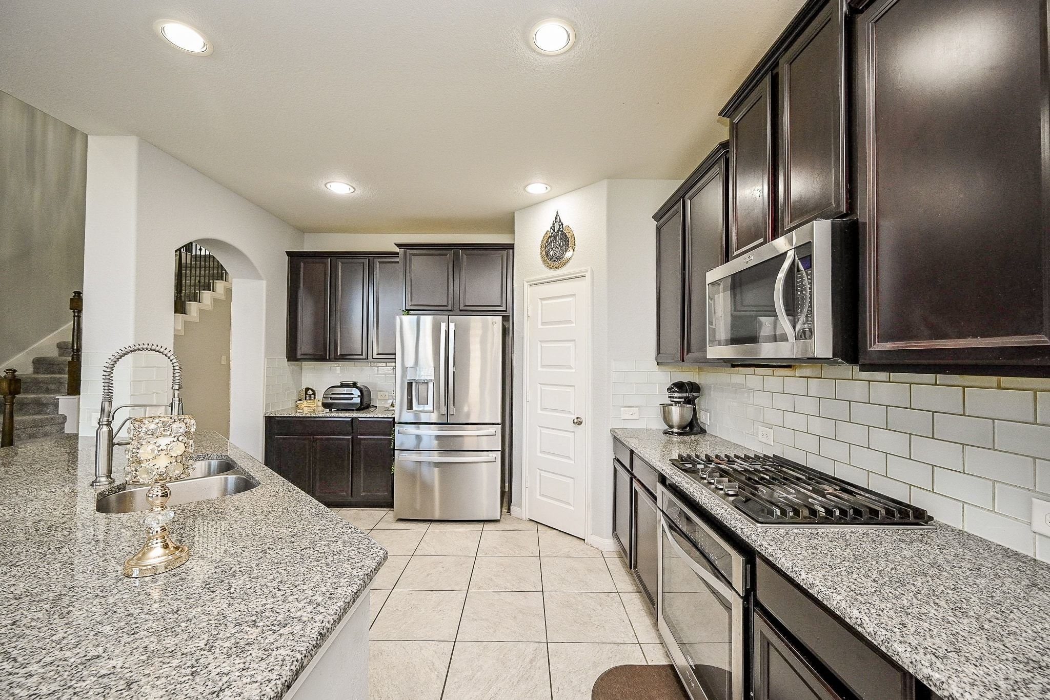 7042 Sliding Rock Circle Spring, TX 77379 - Photo 11 of 44 Discover a modern kitchen with granite countertops, stainless steel appliances, and stylish dark cabinetry—ideal for culinary enthusiasts!