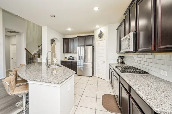 a kitchen with a stove a sink and a refrigerator