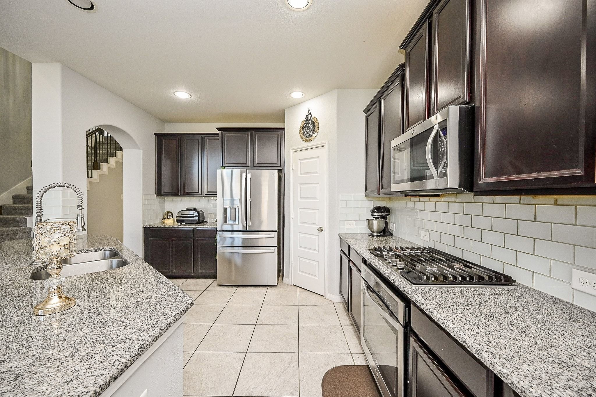 7042 Sliding Rock Circle Spring, TX 77379 - Photo 14 of 44 This gourmet kitchen boasts sleek countertops, modern appliances, and ample cabinetry, perfect for culinary enthusiasts.