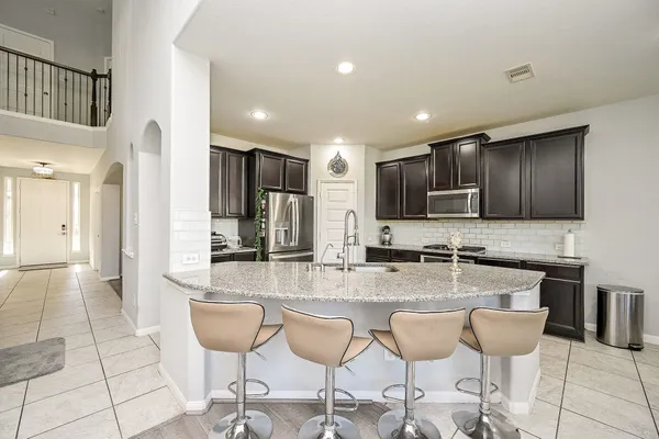 a kitchen with stainless steel appliances kitchen island granite countertop a refrigerator and microwave