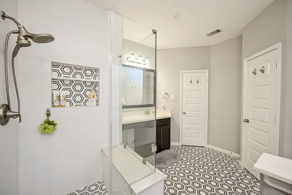 a bathroom with a tub shower sink and mirror