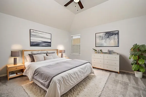 a bedroom with a bed and a chandelier fan