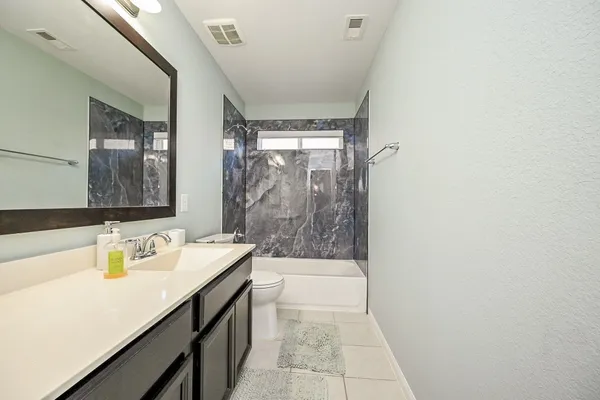 a bathroom with a sink a toilet and mirror