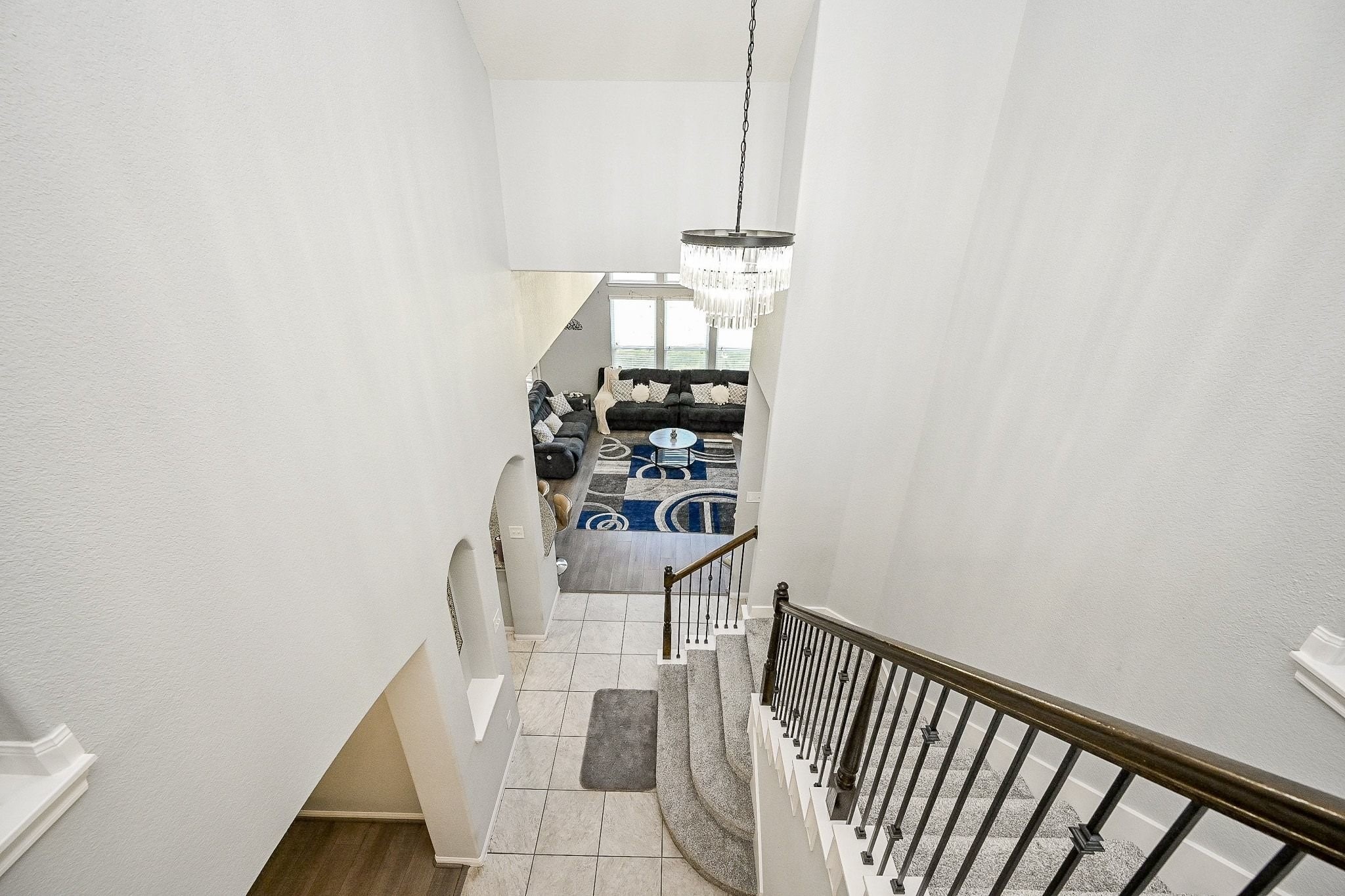7042 Sliding Rock Circle Spring, TX 77379 - Photo 44 of 44 Elegant view of the spacious living room, highlighted by a stunning chandelier and abundant natural light.