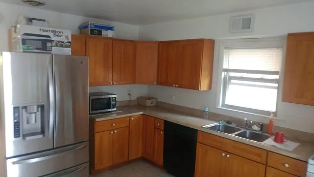 a kitchen with a refrigerator sink and cabinets