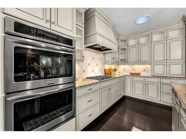 a kitchen with granite countertop white cabinets stainless steel appliances and sink