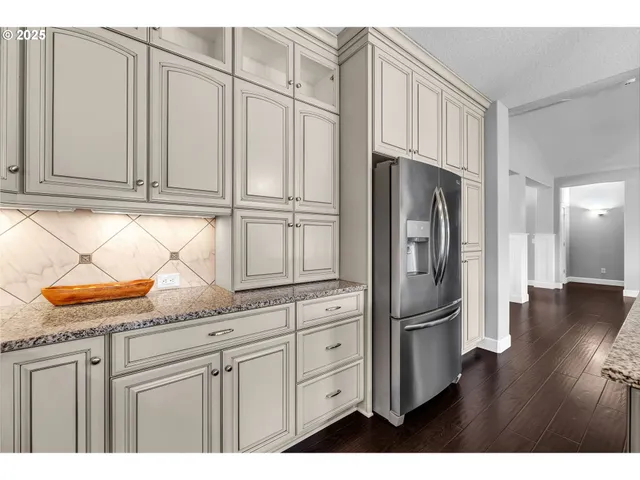 a kitchen with stainless steel appliances granite countertop a refrigerator and a sink