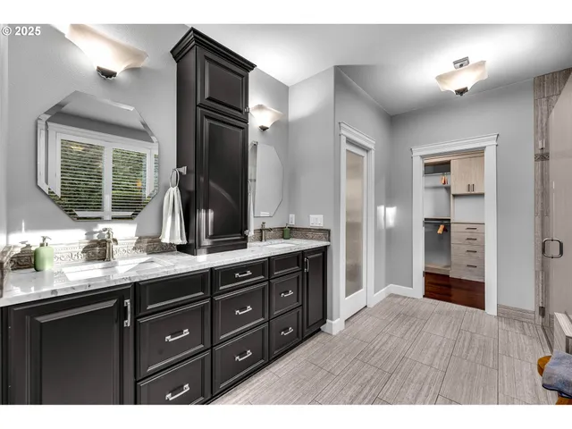 a bathroom with a granite countertop sink a toilet a mirror and shower