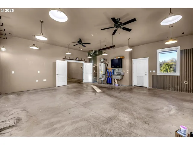 an empty room with ceiling fan and windows