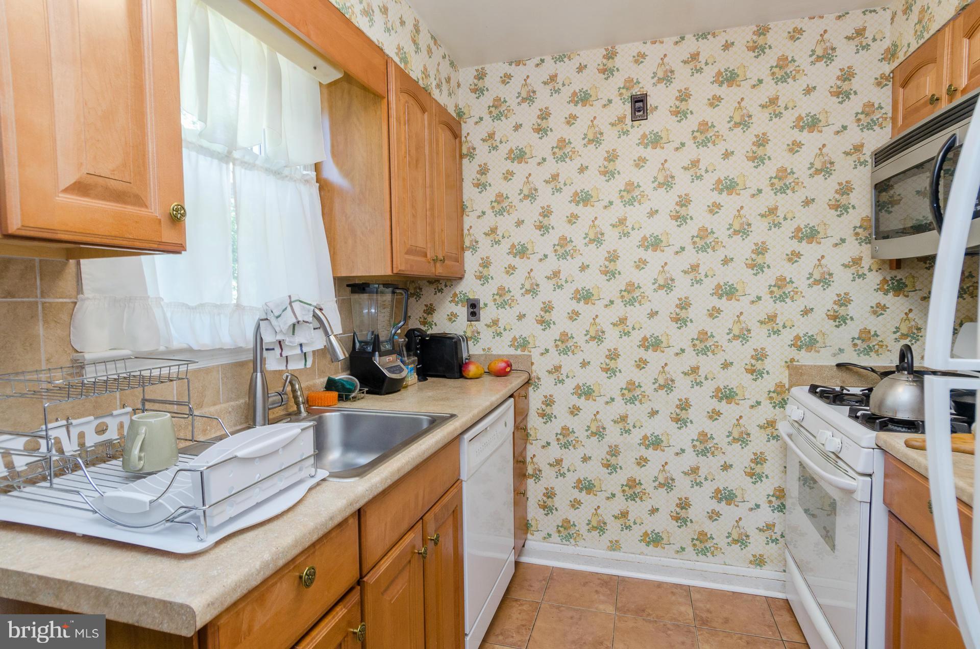 3522 Wild Cherry Road Baltimore, MD 21244 - Photo 7 of 30 a kitchen with a sink a stove and a shower curtain