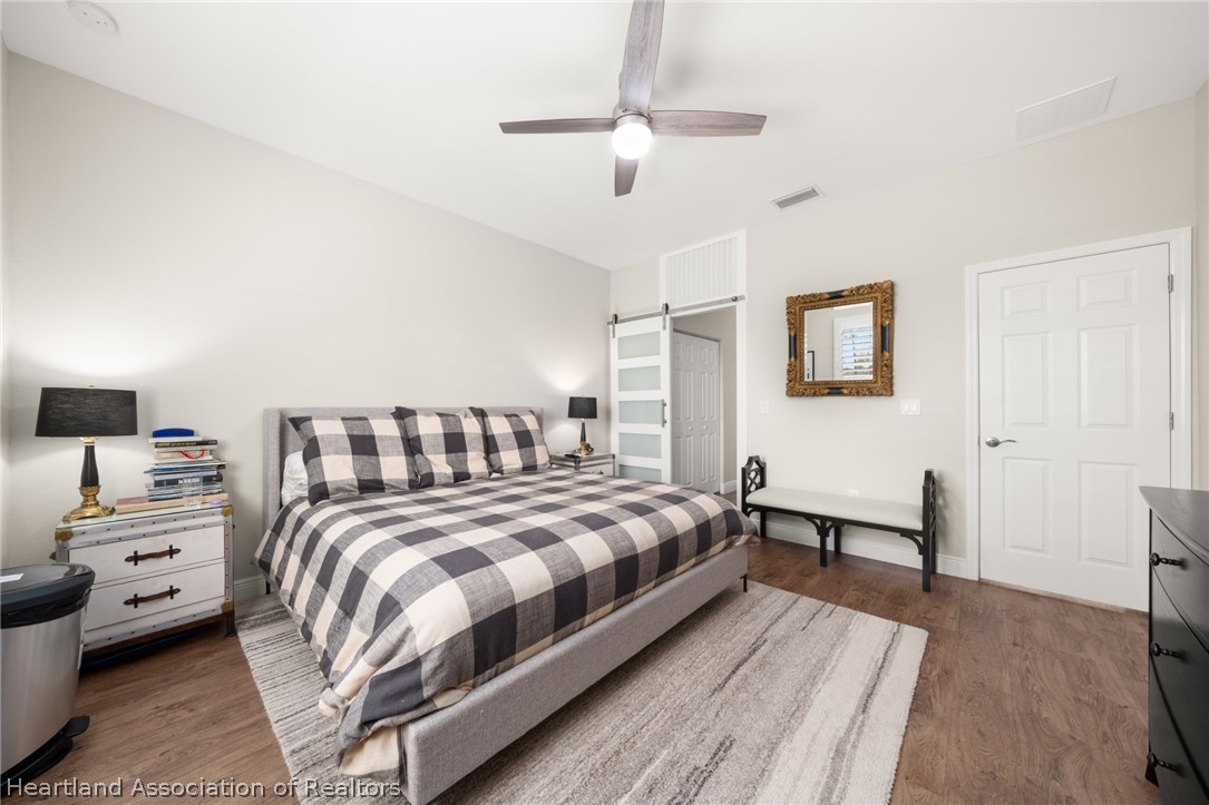 4734 Haw Branch Road, Unit 110 Sebring, FL 33875 - Photo 20 of 50 a bedroom with a bed a couch and a chandelier