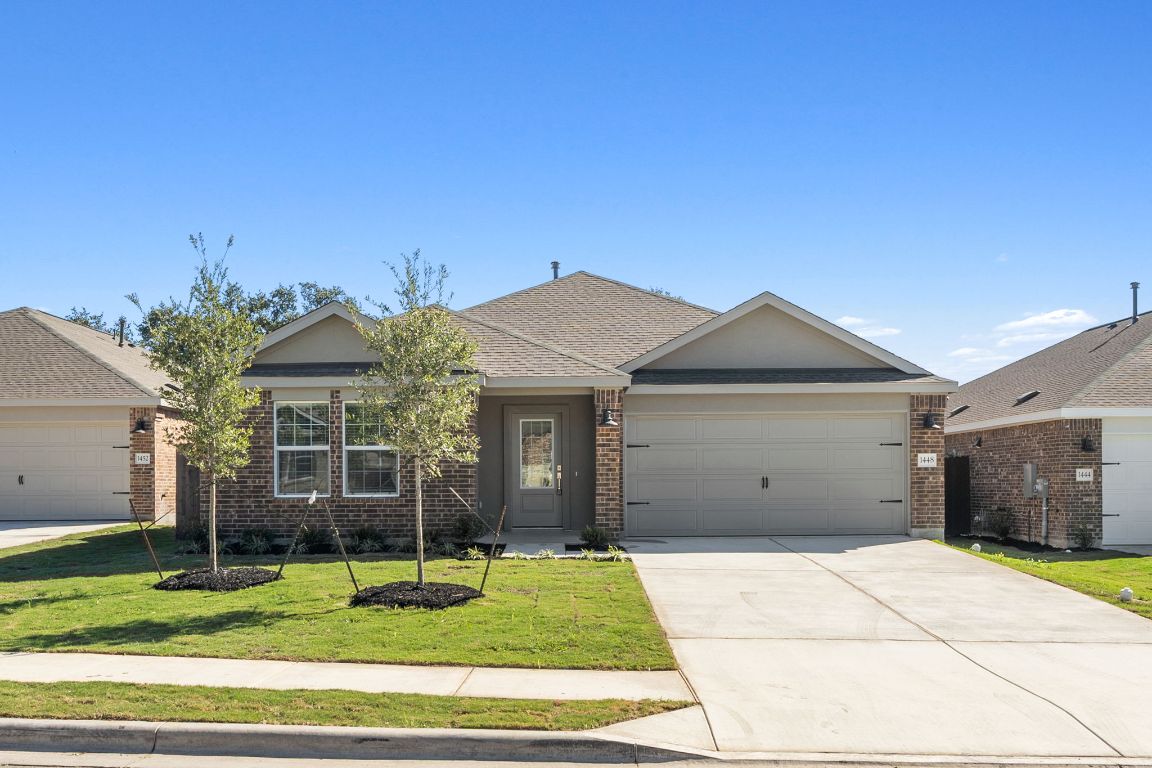 Single story home with a garage, a front yard, concrete driveway, and brick siding