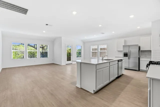 a kitchen with white cabinets and window